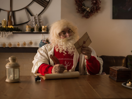 Santa Claus Working at Home. Reading and Writing letters for Childrenの写真素材