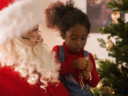 Santa Claus with Child Decorating Christmas Treeの写真素材