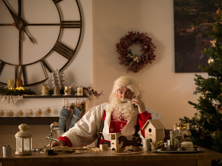 Santa Claus Working at Home. Talking by mobile phoneの写真素材