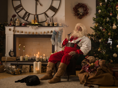 Santa Claus Resting at Home near Christmas Treeの写真素材