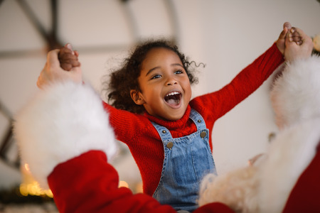 Santa Claus playing with cute african american Child at Homeの写真素材