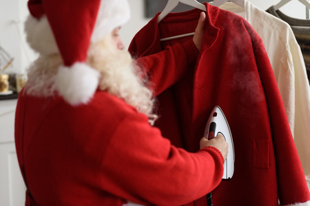 Santa Claus at Home Ironing his Costumeの写真素材