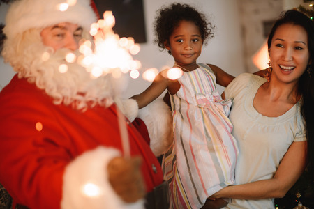 Santa Claus Surprising little Girl and her Mother at Homeの写真素材