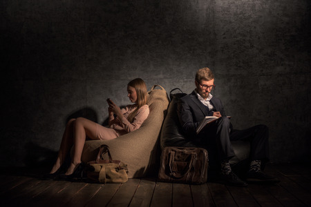 Couple on Beanbags doing their own businessの写真素材
