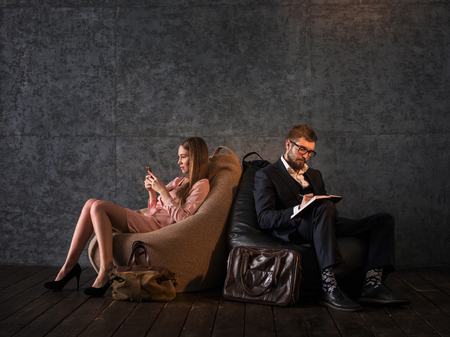 Couple on Beanbags doing their own businessの写真素材
