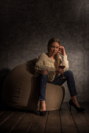 Girl Drinking Wine on Beanbag at homeの写真素材