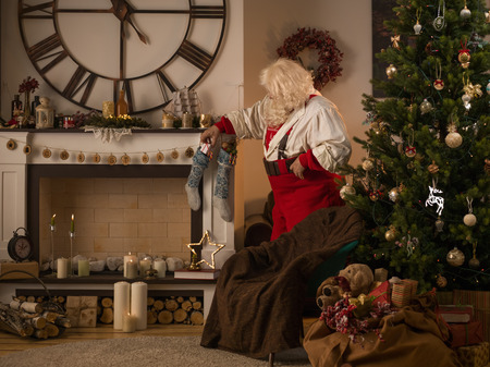 Santa Claus Decorating Fireplace at Homeの写真素材