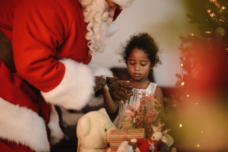 Santa Claus with Child at Home. Presenting Christmas Gifts from his Sackの写真素材