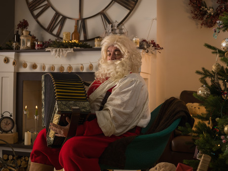 Santa Claus Playing Acordeon at Homeの写真素材