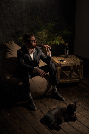 Business man Drinking Wine at home while sitting on beanbagの写真素材