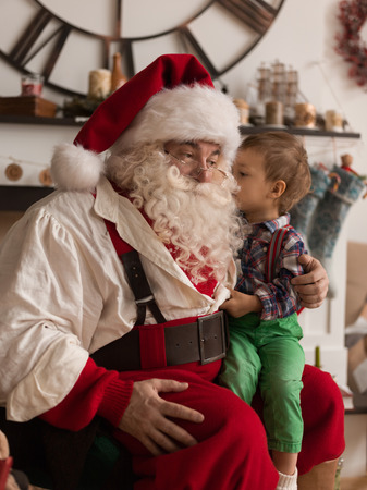 Santa Claus with Child discussing Christmas Wish at Homeの写真素材