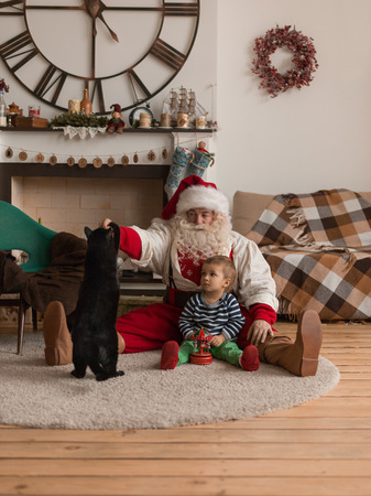 Santa Claus Playing at Home with Child and Catの写真素材