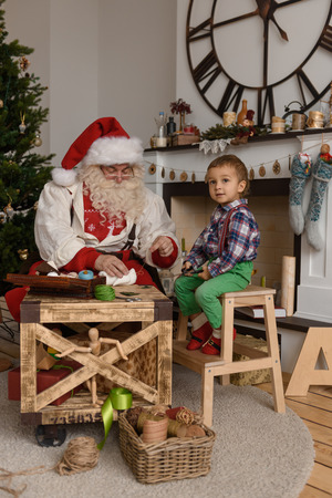Santa Claus with Child sewing together at Homeの写真素材