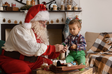 Santa Claus with Child sewing together at Homeの写真素材