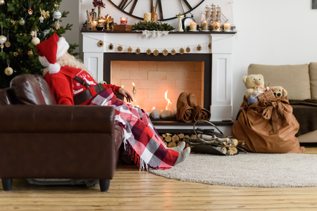 Santa Claus Warming near Fireplace at Homeの写真素材