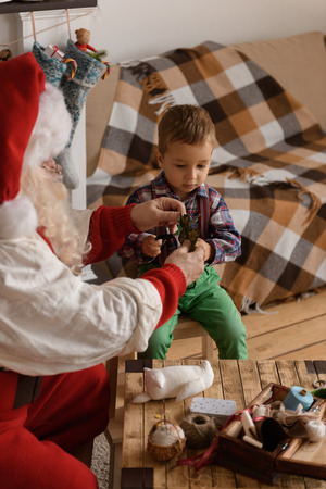 Santa Claus with Child sewing together at Homeの写真素材