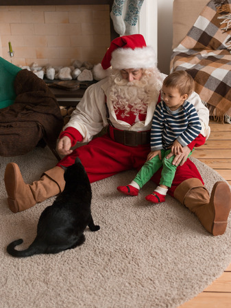 Santa Claus Playing at Home with Child and Catの写真素材