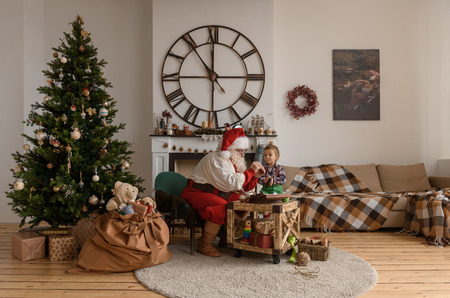 Santa Claus with Child sewing together at Homeの写真素材