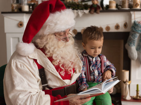 Santa Claus with Child Reading Book at Homeの写真素材