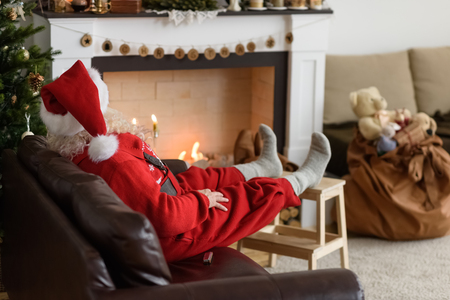 Santa Claus Warming near Fireplace at Homeの写真素材
