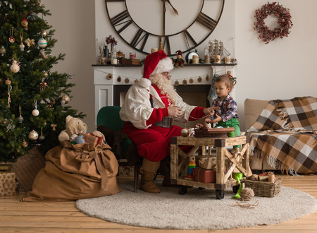 Santa Claus with Child sewing together at Homeの写真素材
