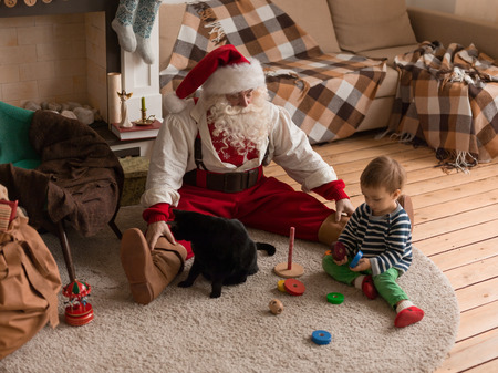 Santa Claus Playing at Home with Child and Catの写真素材