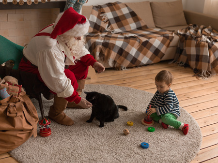 Santa Claus Playing at Home with Child and Catの写真素材