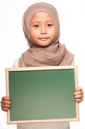 A Malay little girl wearing head scarf holding a blackboardの写真素材