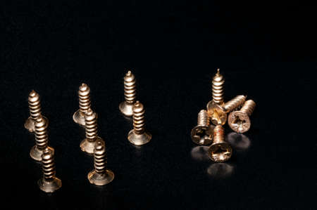 Screws on a black background. The concept of repair and construction.