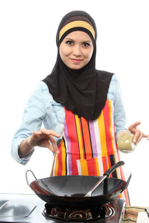 Action capture of a muslim female Chef adding spice on whiteの写真素材