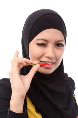 picture of lovely muslim woman with a hot fresh chilli on whiteの写真素材