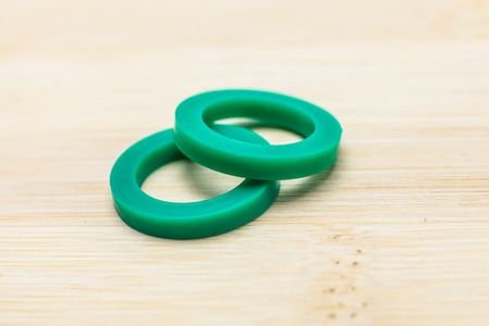 Green Rubber O-Rings on wooden background.の写真素材