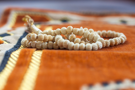tasbih or rosary on praying mat rug or sajdah or sejadahの写真素材