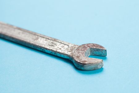 Old rusty wrench on blue background.の写真素材