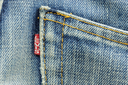 BANGKOK, THAILAND - March 24, 2014: Closeup of Levi's pocket and Levi tag label of logo sewed on a blue jeans isolated on white background.Levi Strauss & Co is a privately held American clothing company.のeditorial素材