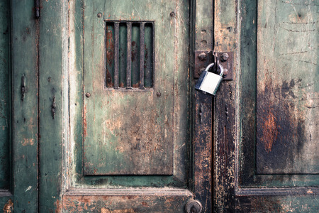 New lock and Rusty padlock on an old wooden doorの写真素材