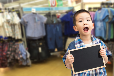 Little asian boy holding a blank blackboard isolated on white backgroundの写真素材