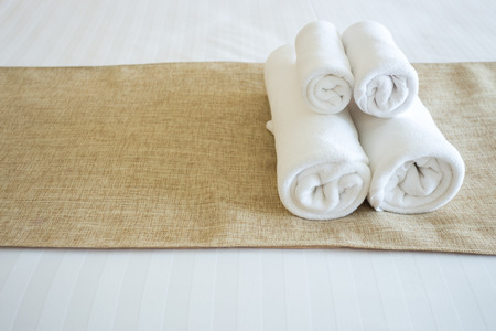 Close up of nice towels on white bed sheet with yellow ribbonの写真素材