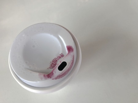 clear white cup of coffee with dark red lipstick mark put on white background with copy space on right sideの写真素材