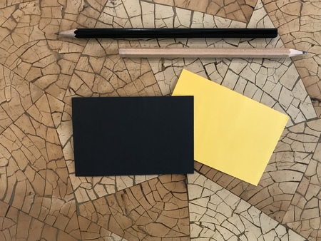 black and yellow notepad with black and brown pencils put on beautiful geometry pattern deskの写真素材