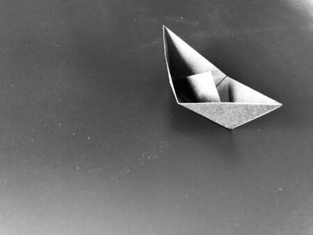 grey paper small boat origami put on grey with little white dot paper background with copy space on...