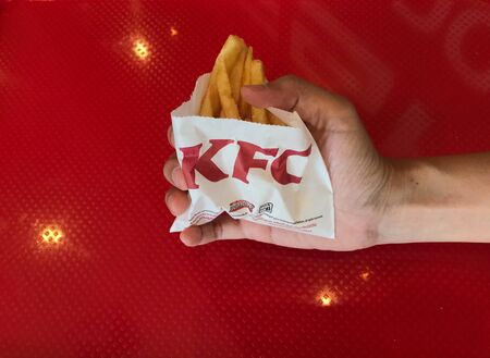 Phuket, Thailand - August 5, 2019: consumer nowaday is with french fries serving at KFC fast food restaurant, Phuket, Thailandのeditorial素材