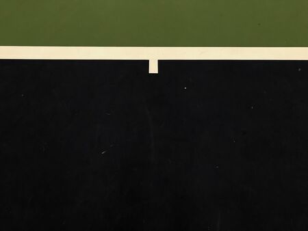 top view of dark blue and white lines and dark green surface at the end of tennis indoor court,...