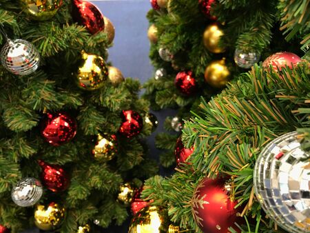 top view shot of variety fantasy Christmas ornament balls on green Christmas tree and blue floor on backgroundの写真素材