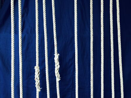 white nylon strings with dark blue cotton fabric on a background, using as the decoration in shopの写真素材