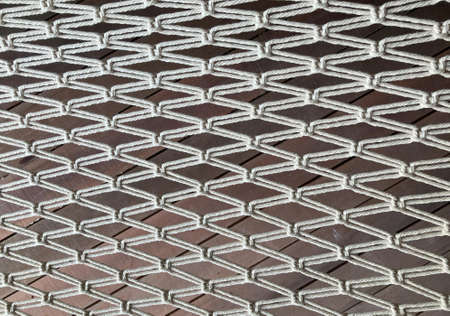 gray ropes are weave as a spider web and brown wooden board on the floor background