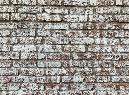 full-frame shot of retro brown brick wall which is painted with white painting color, used for backgroundの写真素材