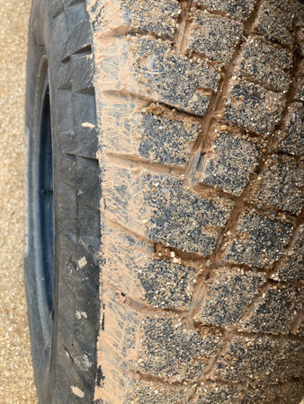 sand and dirt full cover the black car's wheel on the country roadの写真素材