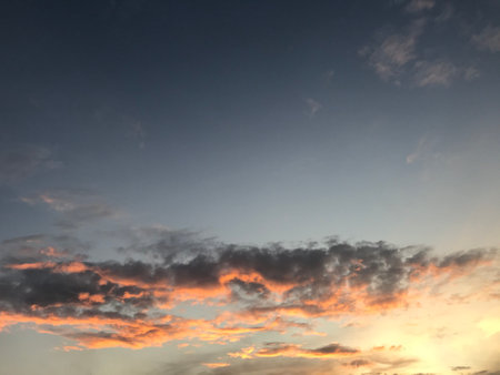 Golden and black clouds like fire spread out, covering the sunset sky in beautiful layersの写真素材