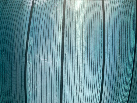 Green shading net was spread over the walkway in the market, allowing a glimpse of the bright sunlit skyの写真素材